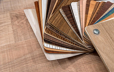 Vinylboden Vinylböden von HolzPartner in Rathenow – große Auswahl an Dekoren für Berlin und Brandenburg. Von hellen Holzoptiken bis zu modernen Designs bietet Vinylboden vielfältige Gestaltungsmöglichkeiten, ist strapazierfähig, pflegeleicht und für jeden Wohnbereich geeignet. Bildbeschreibung: Musterfächer mit verschiedenen Vinylboden-Dekoren in Holz- und Designoptik, ausgelegt auf einem Holztisch.