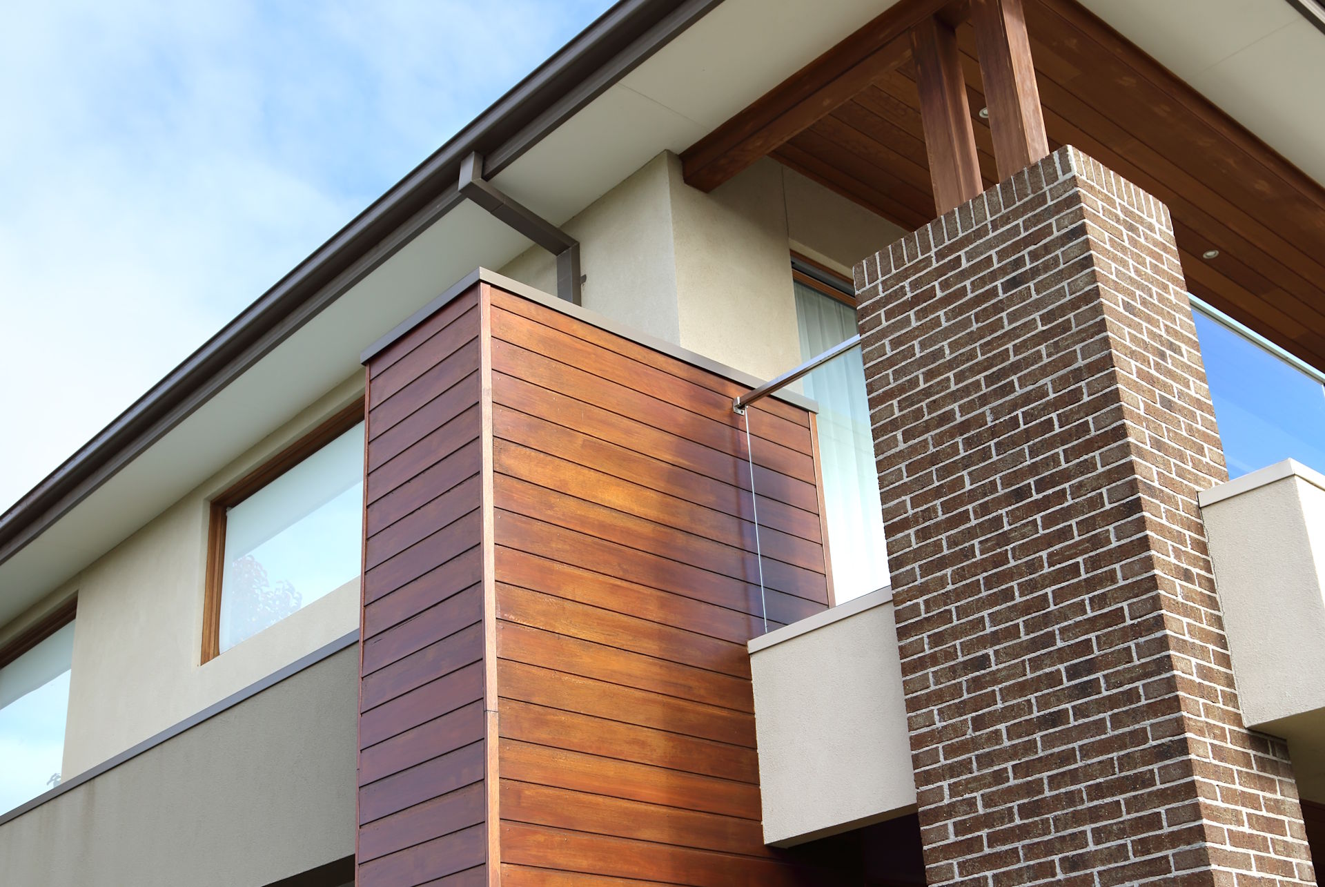 Holzfassade Eine Holzfassade von HolzPartner in Rathenow verleiht Ihrem Haus in Berlin und Brandenburg eine warme, natürliche Ausstrahlung und verbessert zugleich die Wärmedämmung. Mit langlebigen und wetterfesten Hölzern gestalten Sie eine stilvolle Fassade, die Wertigkeit und Behaglichkeit ausstrahlt. Bildbeschreibung: Moderne Hausfassade mit vertäfelter Holzverkleidung, kombiniert mit Putz und gemauertem Kamin.